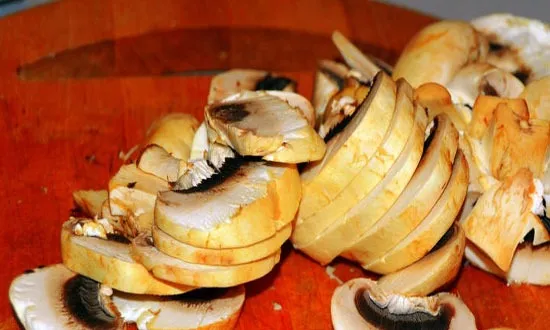 Тщательно вымойте грибы и разрежьте их на две части.