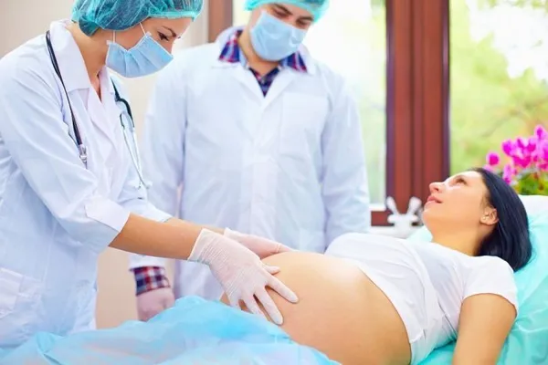 два врача осматривают беременную женщину