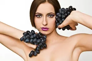 женщина держит черный виноград